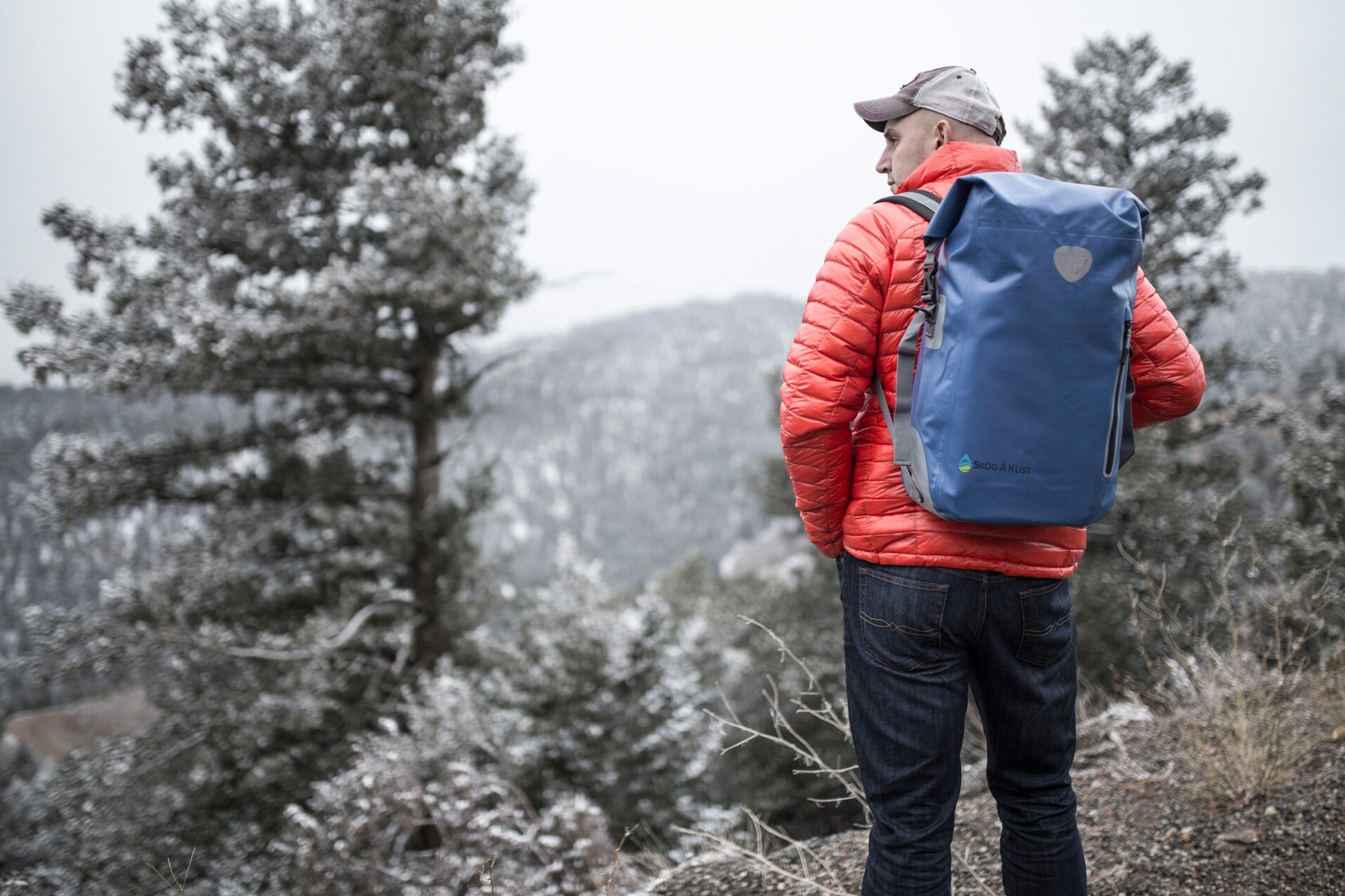 Outdoors person wearing a blue Skog A Kust 25L BackSak backpack in the bush in winter