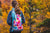 The Skog A Kust tie dye GymSak being worn by a girl walking in the outdoors.
